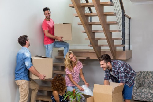 Removal professionals dismantling office desks for relocation