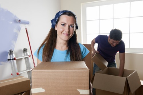 Professional movers carrying furniture through a flat stairwell